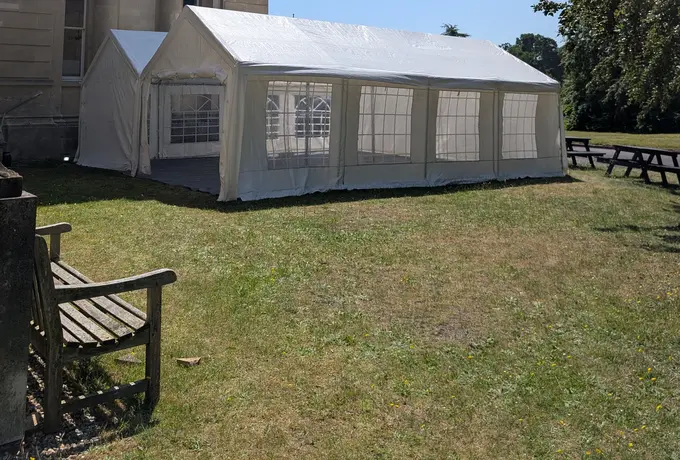 Linked marquees with sides and windows outside a period stone building for a corporate event